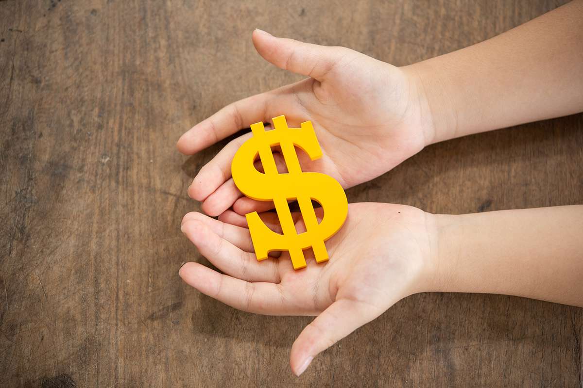 The yellow dollar symbol on hands child for the investment or saving of people with differences diversity for insurance, education, safety life for good and stable in future of family